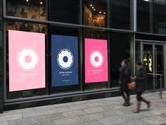 two people walking past an advertisement for donuts