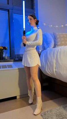 a woman in white is holding a light saber