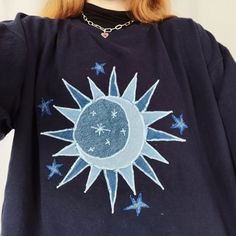 a woman with red hair wearing a blue sweatshirt with the moon and stars on it