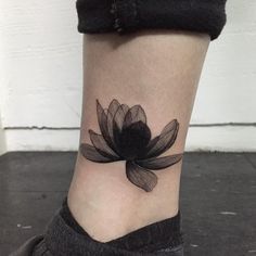 a black and white photo of a flower on the ankle, with its petals still attached