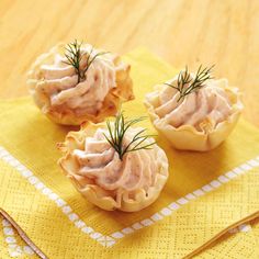 three small appetizers are sitting on a yellow napkin