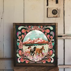 an image of two horses in the wild painted on wood panelling with paintbrushes