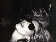 black and white photograph of a woman wearing sunglasses with her hair blowing in the wind