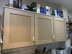 the kitchen cabinets are all beige and have no doors or drawers on top of them