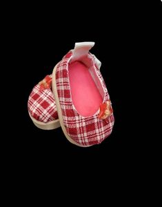 red and white plaid slippers with flowers on the soles, one is open