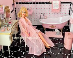 a barbie doll sitting in a pink bathroom