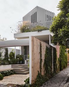 a house with plants growing on the side of it's walls and roof area