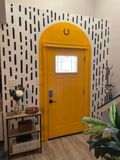 a bright yellow door is in front of a black and white wall