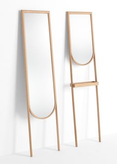 two mirrors are standing next to each other in front of a white wall and one is leaning against the wall