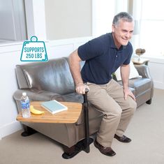 a man sitting on top of a couch next to a table