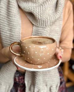 a woman holding a coffee cup and saucer