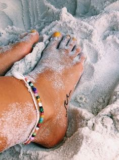 a person's feet covered in sand and beads