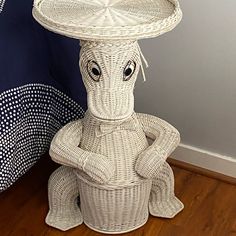 a wicker basket sitting on top of a wooden floor next to a blue and white wall