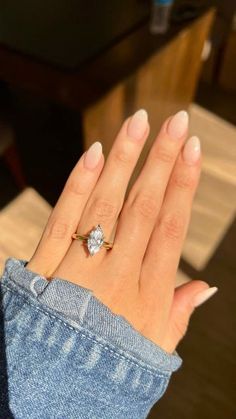 a woman's hand with a diamond ring on it