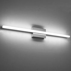 a bathroom light that is on the wall in black and white photo with dim lighting