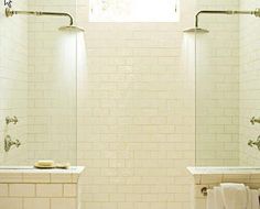 two white sinks sitting next to each other under a window in a bathroom with brick walls