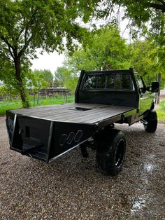 a black truck parked on top of a gravel road