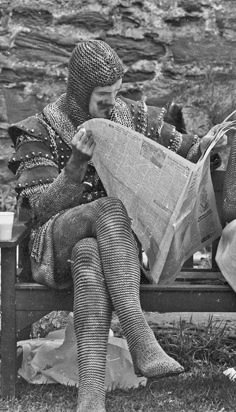 a woman sitting on a bench reading a newspaper