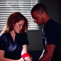 a man and woman with bandages on their arms looking at each other in the dark