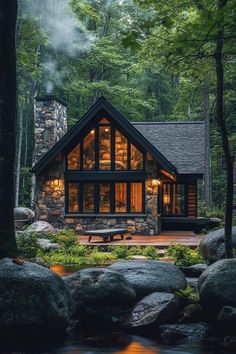 a cabin in the woods is lit up at night with lights shining on it's windows