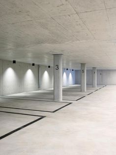 an empty parking garage with several lights on the ceiling and no one in the area