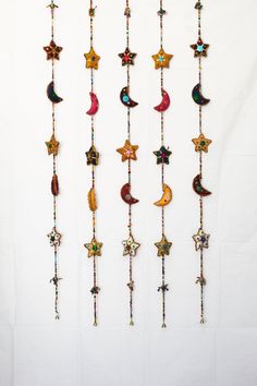 a group of stars and crescents hanging from strings on a white wall next to each other