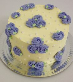 a yellow and blue cake with purple flowers on it