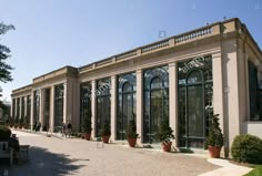 an old building with many windows and plants in the front