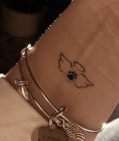 a close up of a person's wrist with a dog paw tattoo on it