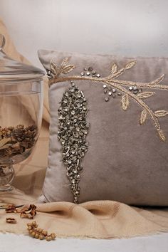 a decorative pillow and glass vase on a table