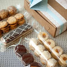 an assortment of cookies and pastries on a table next to a box of cookies