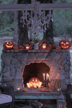 an outdoor fireplace decorated with pumpkins and candles