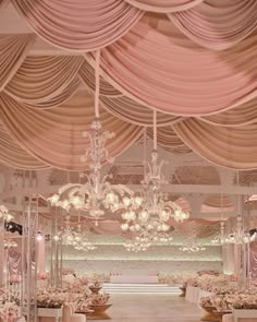 an elegant wedding ceremony setup with chandeliers and flower centerpieces on the ceiling