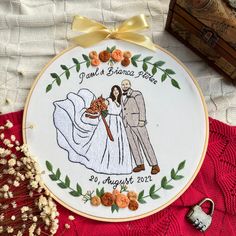 a wedding embroidered on a white cloth with gold ribbon and buttons around it, next to a pair of scissors