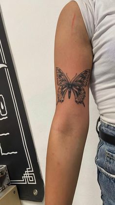 a woman with a butterfly tattoo on her arm