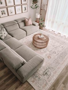 a large sectional couch sitting on top of a wooden floor next to a white rug