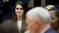 a woman with long hair sitting next to other people