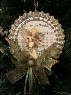 a christmas ornament hanging on a tree with music sheets in the back ground