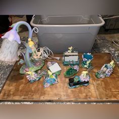 there are many figurines sitting on the table next to a trash can and other items