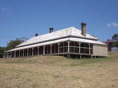 an old wooden house sitting on top of a dry grass field