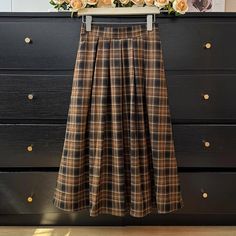 Pleated plaid midi skirt in cozy colors to go with your autumnal fits. Features an elastic waist back. Lined. One Size: 26"-36" waist, 31" length Casual Midi-length Winter Bottoms, Casual Winter Midi Bottoms, Casual Midi-length Bottoms For Winter, Casual Midi Length Bottoms For Winter, Fall Workwear Pleated Skirt, Casual Knee-length Pleated Winter Skirt, Casual Plaid Skirt For Fall, Casual Plaid Skirt For Winter, Casual Plaid Winter Skirt