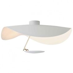 a white table lamp with a light on it's side and an object in the middle