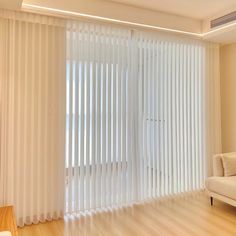 an empty living room with white vertical blinds