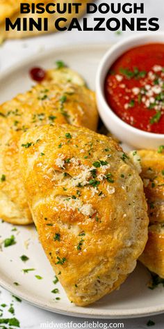 two mini pizzas on a plate with dipping sauce