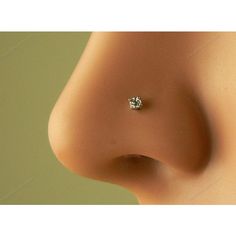 a close up view of the side of a woman's nose with a single diamond on it