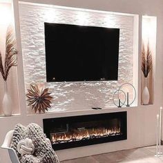 a living room with a large television mounted on the wall next to a fire place