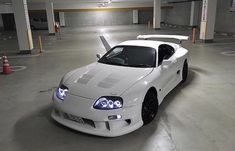 a white sports car parked in a parking garage