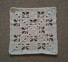 a white crocheted square on the ground