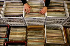 a person picking up records from bins in a store