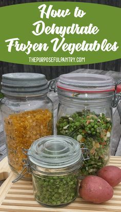 three jars filled with different types of vegetables on top of a wooden table next to potatoes